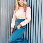 taupe sweater with a slight peach undertone with ruffled and puff sleeves on shoulders. Sweater is color block with orange and emerald green