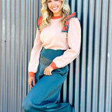 taupe sweater with a slight peach undertone with ruffled and puff sleeves on shoulders. Sweater is color block with orange and emerald green