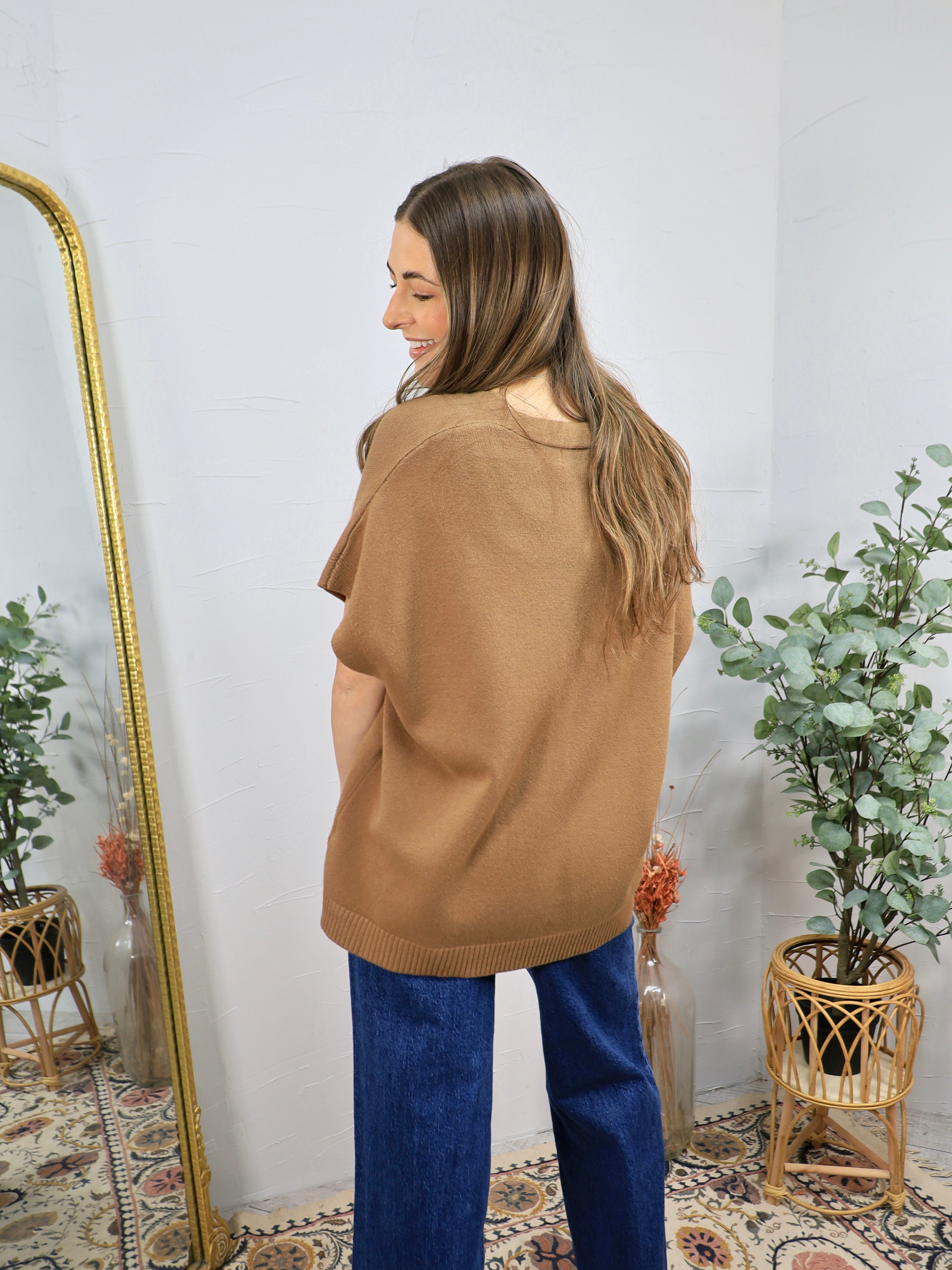 Camel brown short-sleeve oversized knit sweater top styled with wide-leg blue denim jeans, back view.