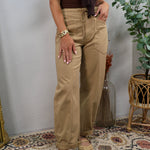 Women wearing wide-leg latte tan drawstring trousers with cuffed hem and brown bodysuit