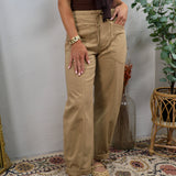 Women wearing wide-leg latte tan drawstring trousers with cuffed hem and brown bodysuit