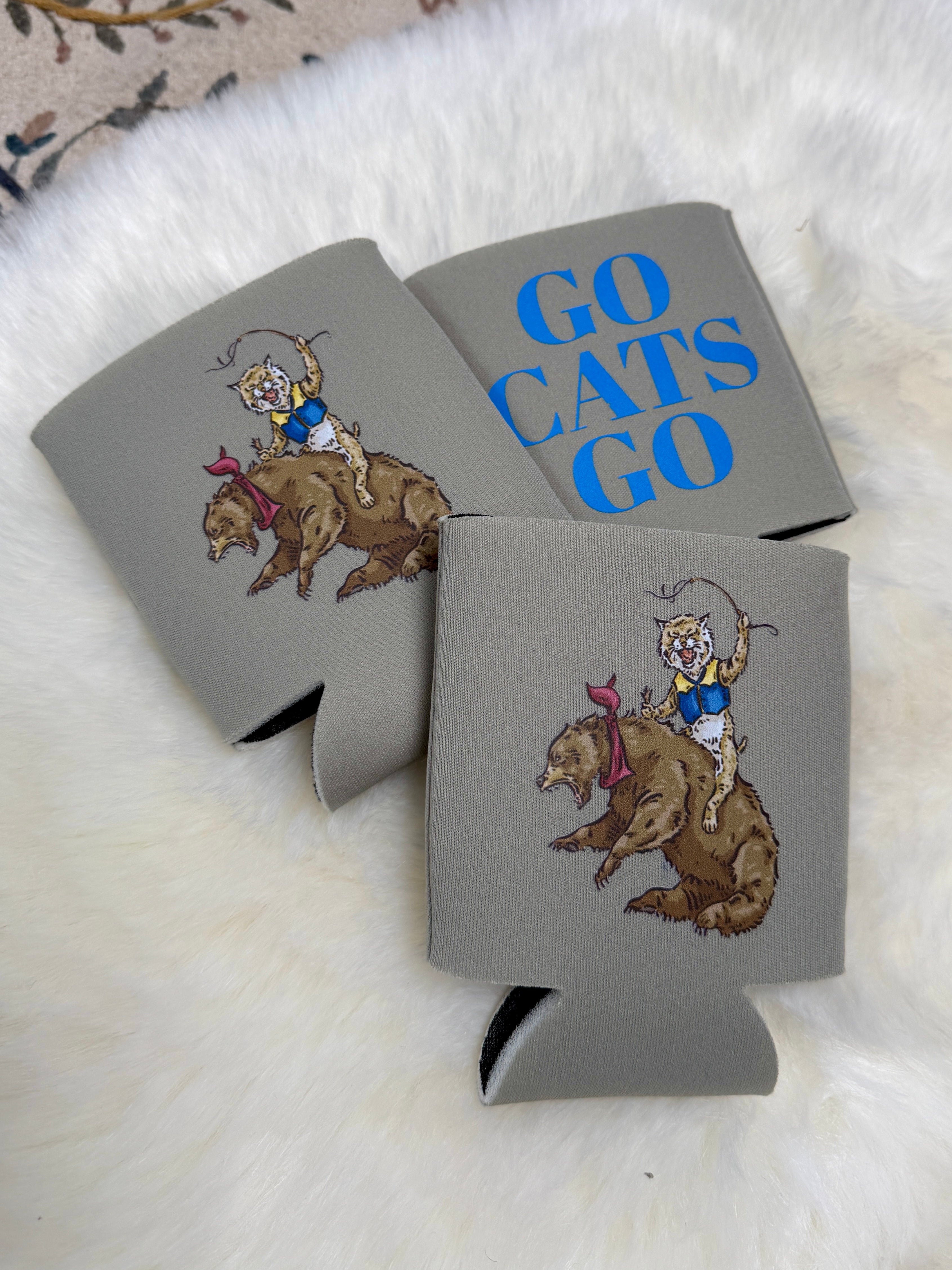 Grey foam can koozie featuring illustrated wildcat riding a bear, with "Go Cats Go" in bold blue text.