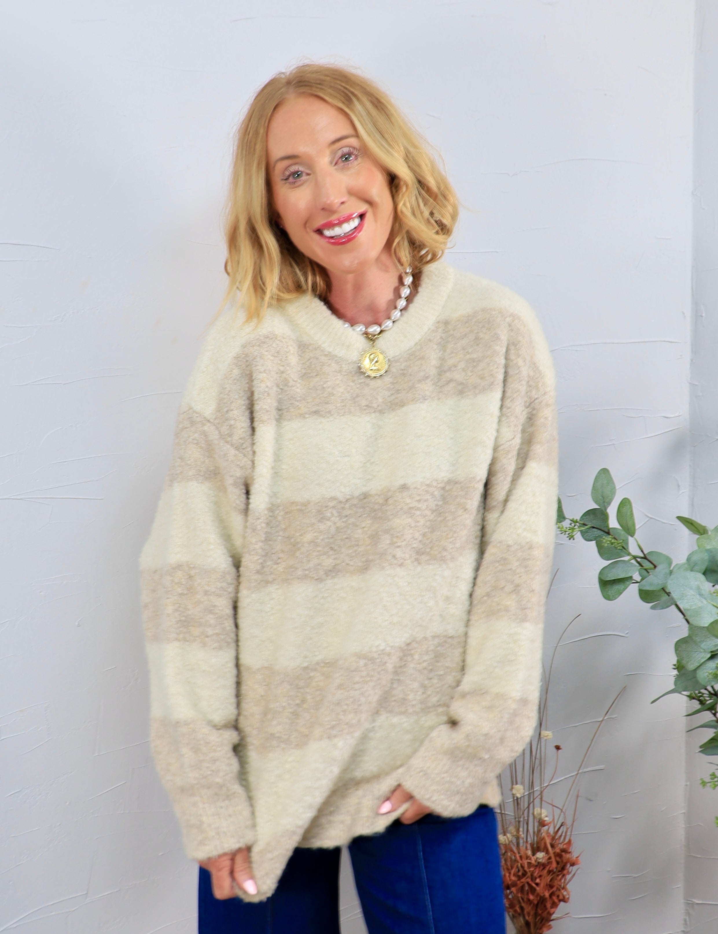 Oversized cream and tan striped fuzzy crewneck sweater styled with blue velvet pants and a pearl necklace.