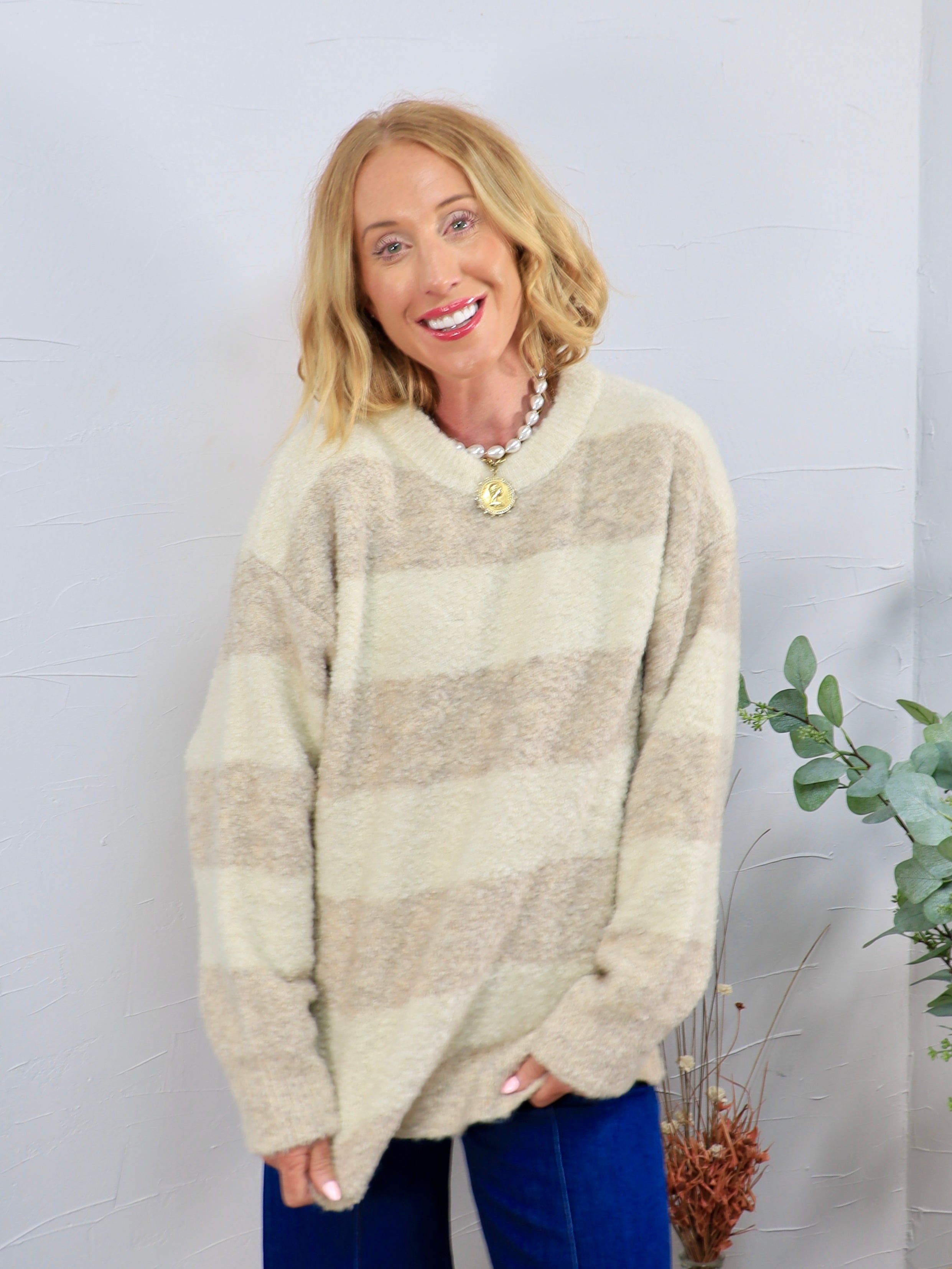 Oversized cream and tan striped fuzzy crewneck sweater styled with blue velvet pants and a pearl necklace.