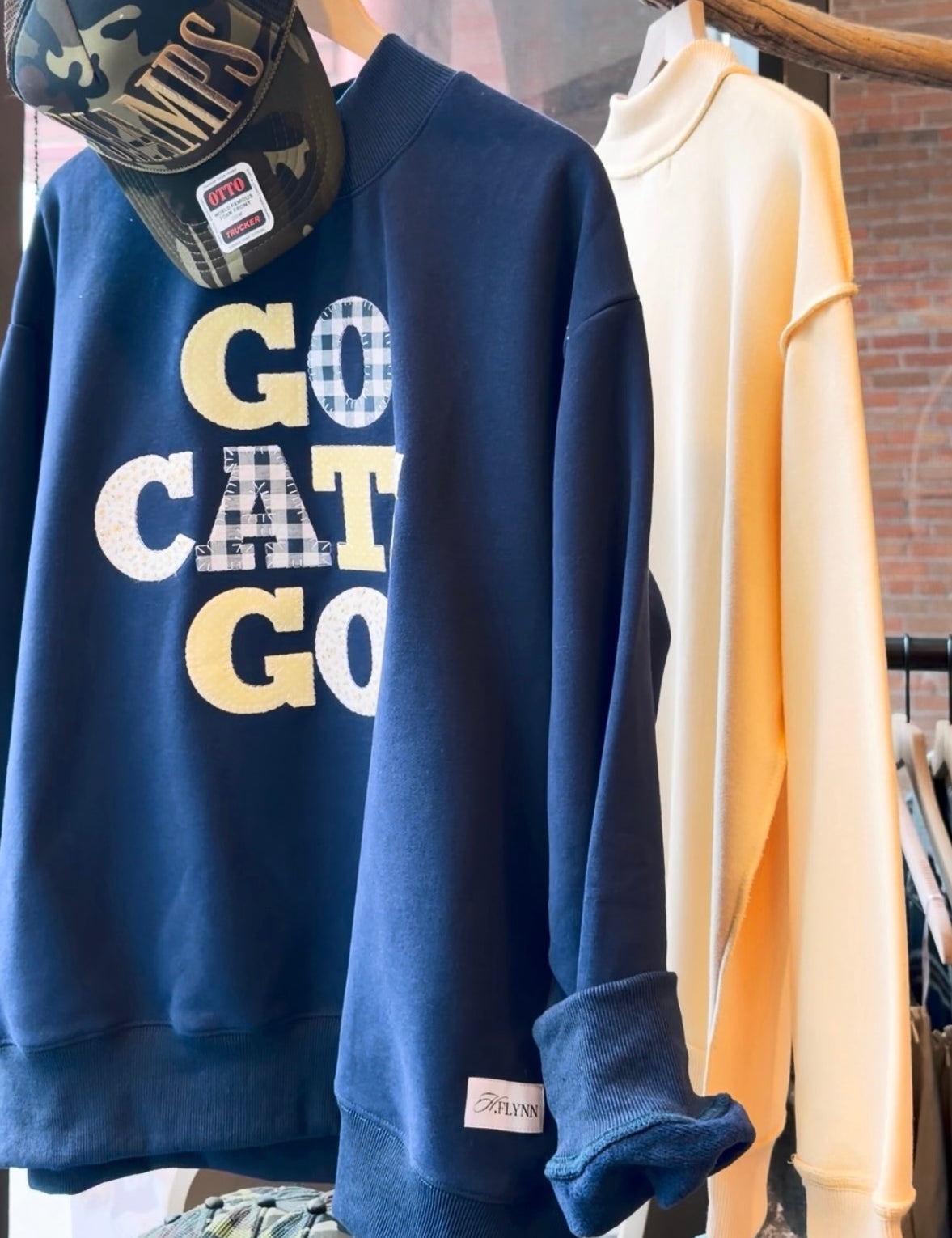 Navy blue game day sweatshirt with Go Cats Go gingham appliqué lettering on boutique hanger