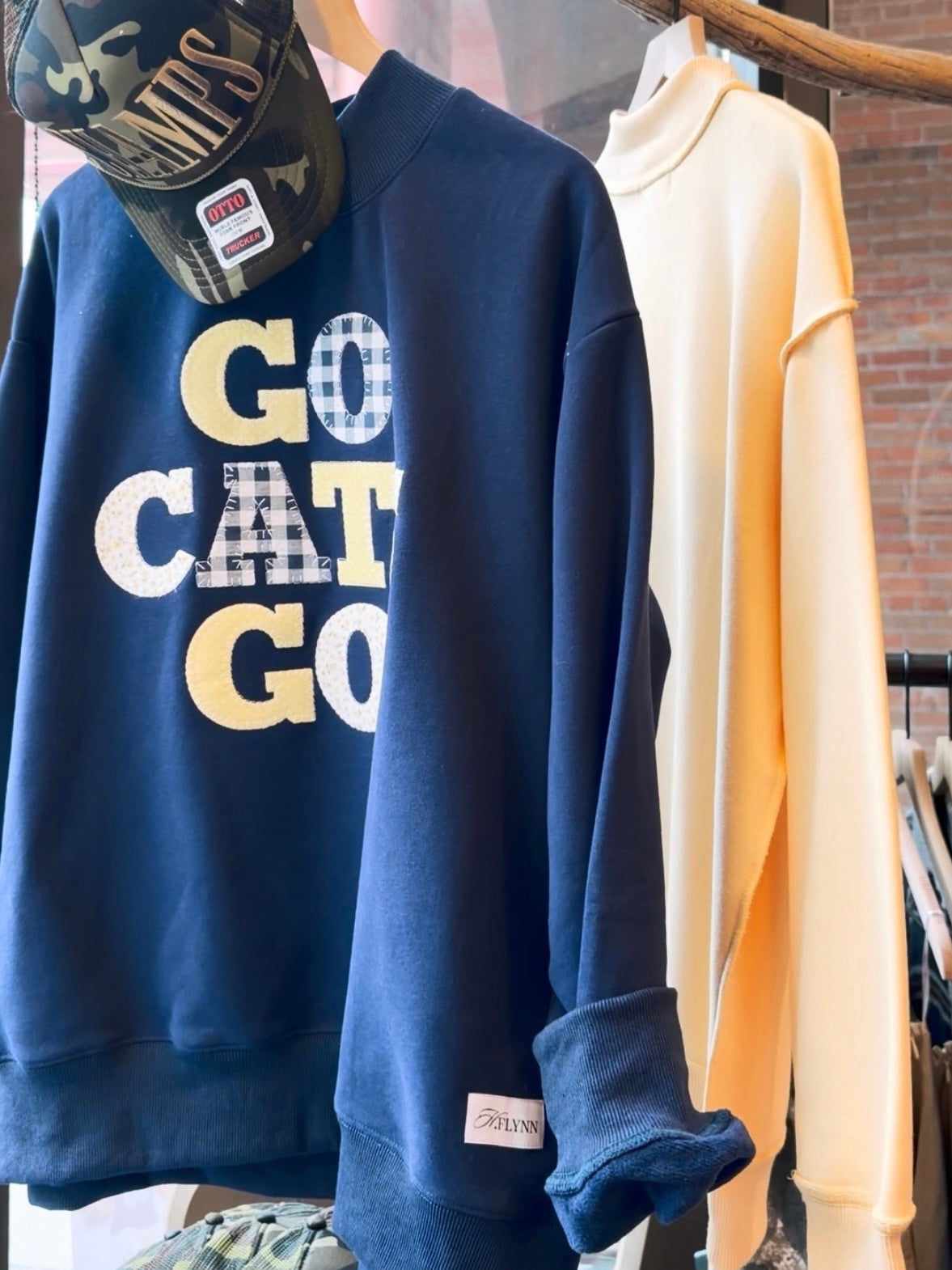 Navy blue game day sweatshirt with Go Cats Go gingham appliqué lettering on boutique hanger