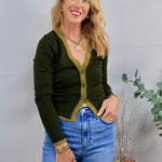 Dark olive green cardigan with contrast trim, gold buttons, styled with blue high-waist jeans and gold jewelry.
