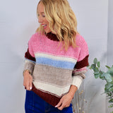 Chunky knit striped crewneck sweater in pink, burgundy, blue, and gray, styled with blue jeans.