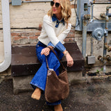 Woman wearing cream Oxford detailed sweater over denim shirt with flare jeans and ankle boots