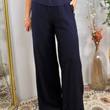 Woman wearing navy blue wide-leg loungewear pants with elastic waistband and side pockets