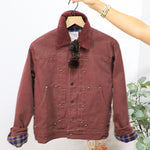 Burgundy snap-button trucker jacket with plaid flannel lining and corduroy collar on wooden hanger