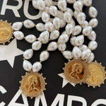 Pearl beaded necklace with gold coin pendants engraved "Love Each Other More," crystal-encrusted borders.