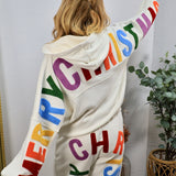 White hoodie and jogger set with colorful "Merry Christmas" lettering, modeled from behind, arms outstretched.