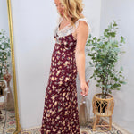 Burgundy floral maxi dress with white lace neckline trim, worn by blonde model with heeled sandals.