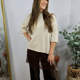 Cream short-sleeve knit top with mock neck, worn with dark brown wide-leg lace-trim pants.