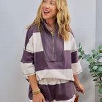 Woman wearing a purple and cream striped half-zip oversized lounge top with matching shorts