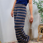 Wide-leg navy striped knit lounge pants with burgundy and cream horizontal stripes, styled with navy top