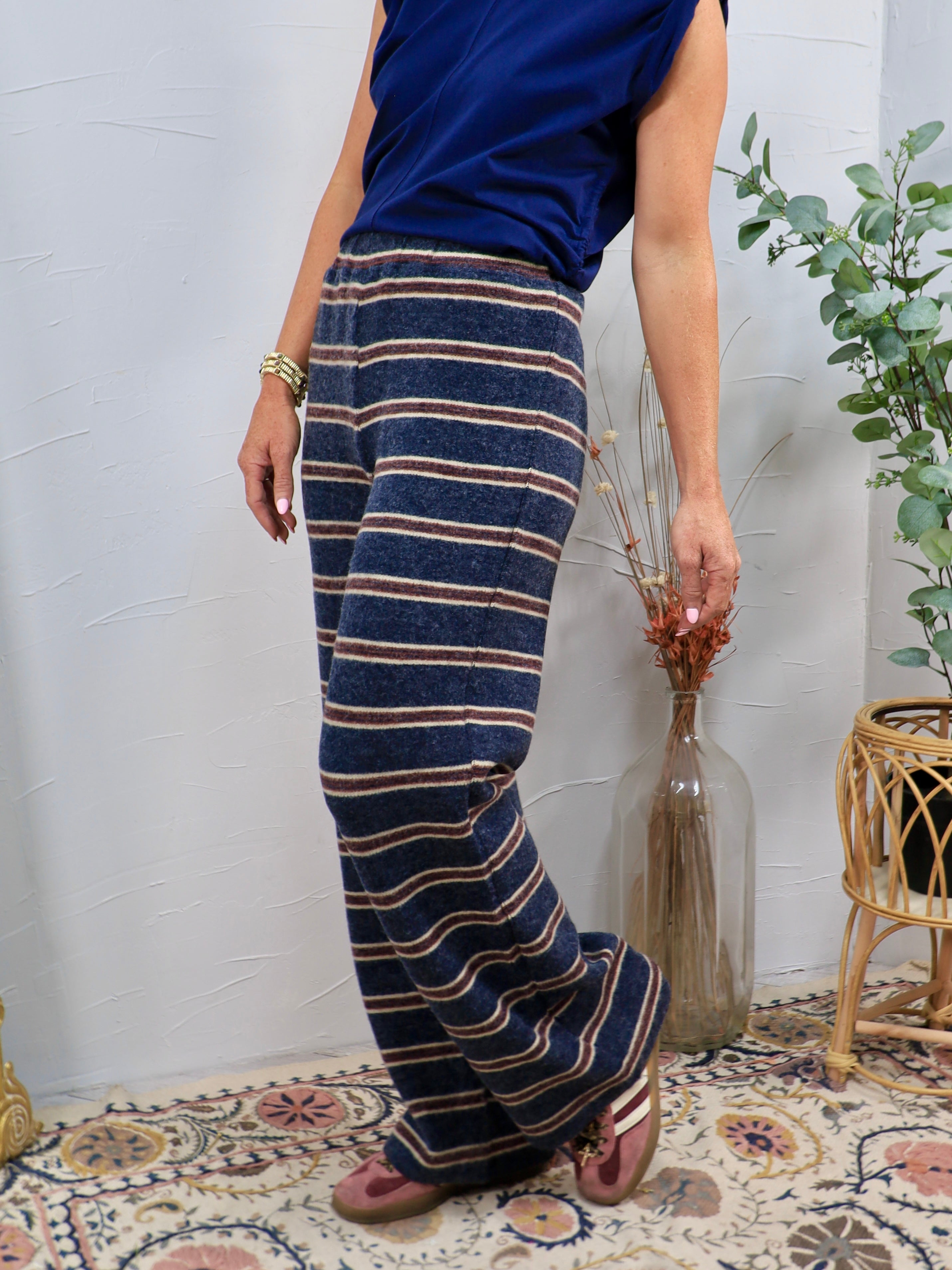 Wide-leg navy striped knit lounge pants with burgundy and cream horizontal stripes, styled with navy top