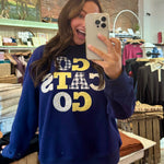 Navy blue "Go Cats Go" graphic sweatshirt with patchwork appliqué lettering in gold and gingham patterns.
