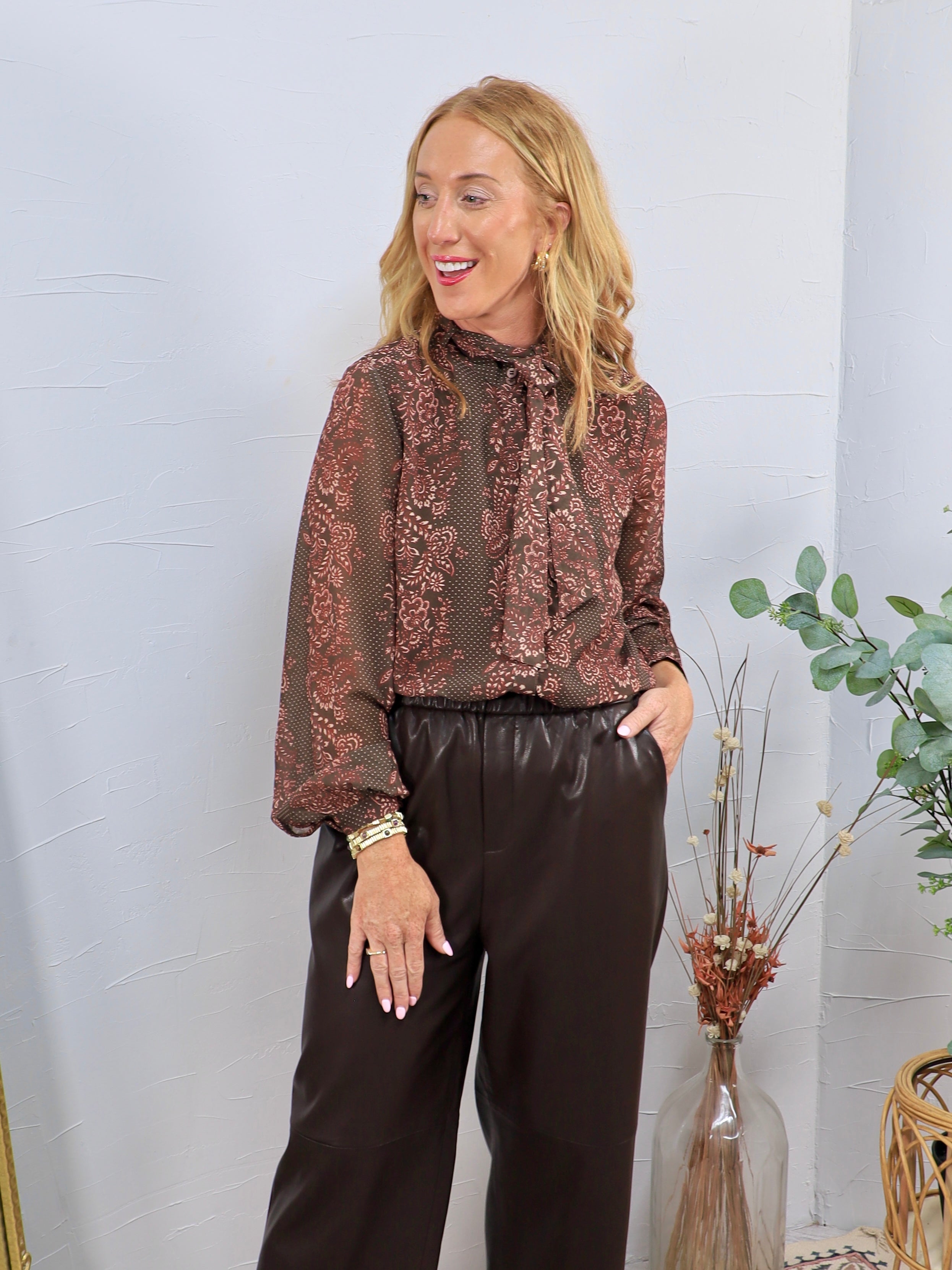 Brown and mauve floral print chiffon blouse with pussy bow neck tie, styled with dark chocolate faux leather wide-leg trouser