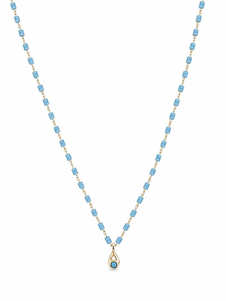Gold-tone necklace with sky blue cylindrical beads and small turquoise teardrop pendant on white background
