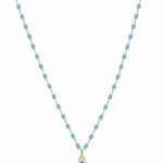 Gold-tone necklace with sky blue cylindrical beads and small turquoise teardrop pendant on white background
