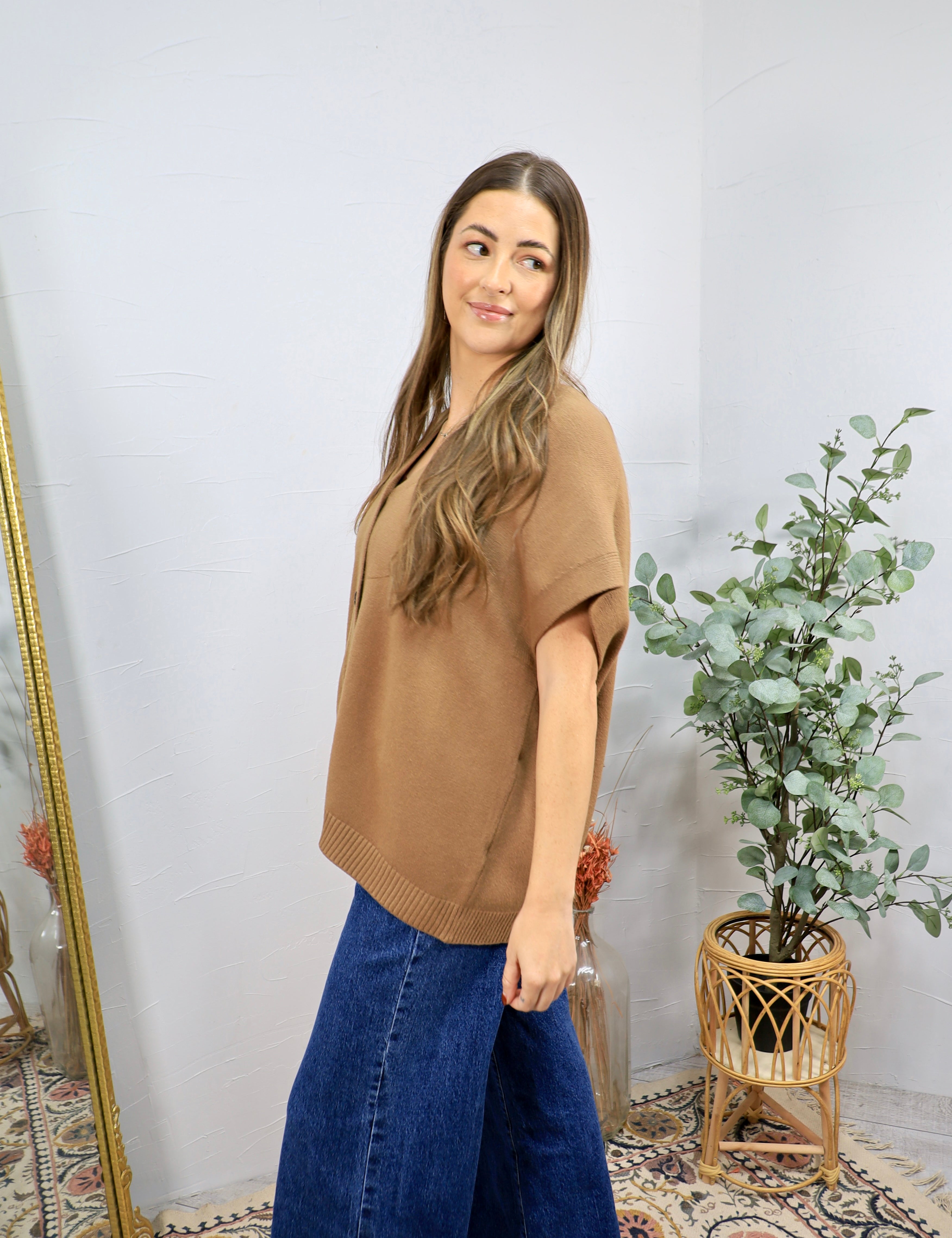 Camel short-sleeve knit polo sweater top with ribbed hem, styled with wide-leg dark blue jeans.