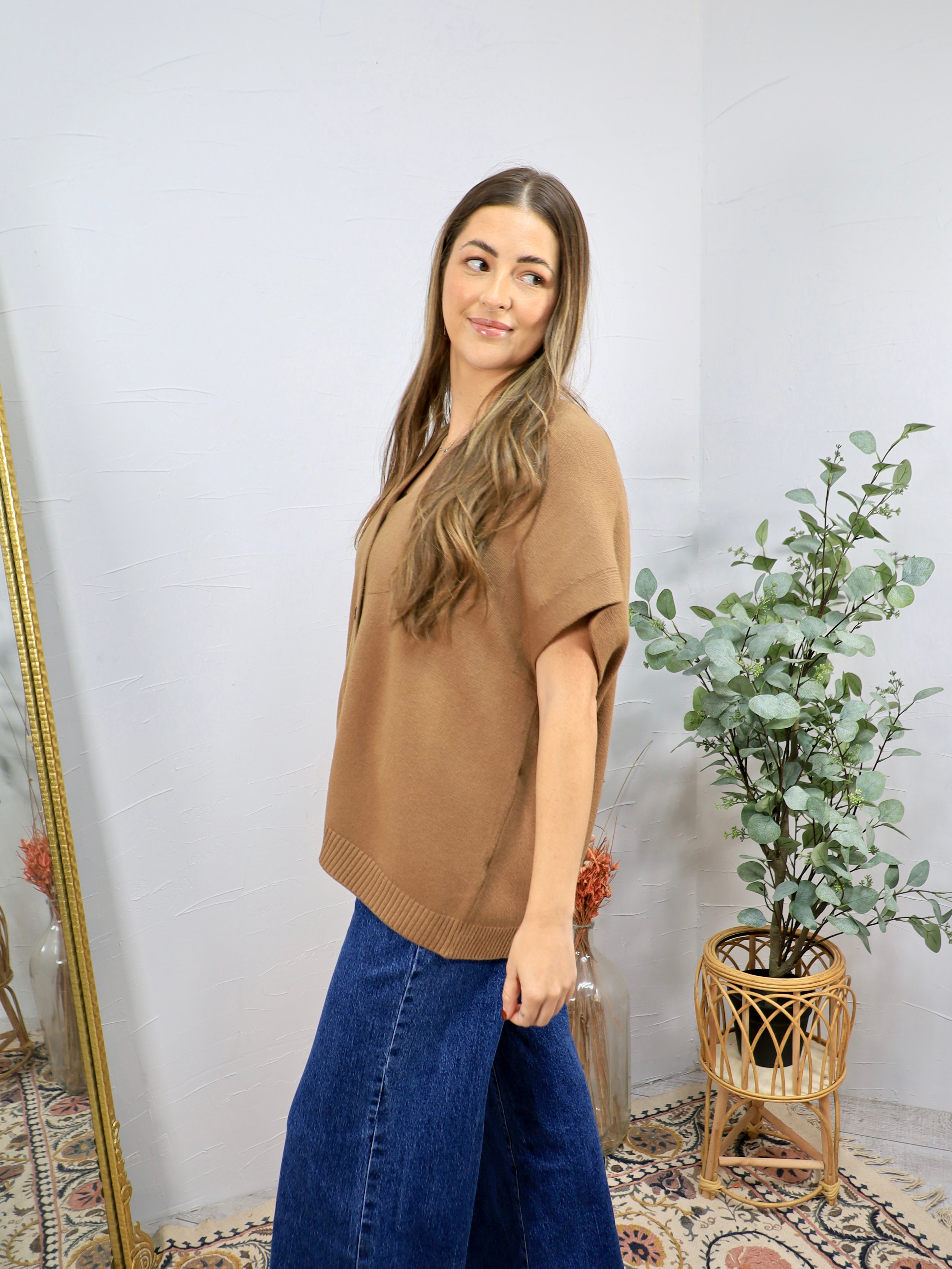 Camel short-sleeve knit polo sweater top with ribbed hem, styled with wide-leg dark blue jeans.