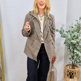 Brown plaid double-breasted blazer with attached olive hoodie, styled over cream sweatshirt and dark jeans.