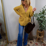 Woman wearing a chartreuse mustard oversized button-front cardigan with wide-leg jeans and brown boots
