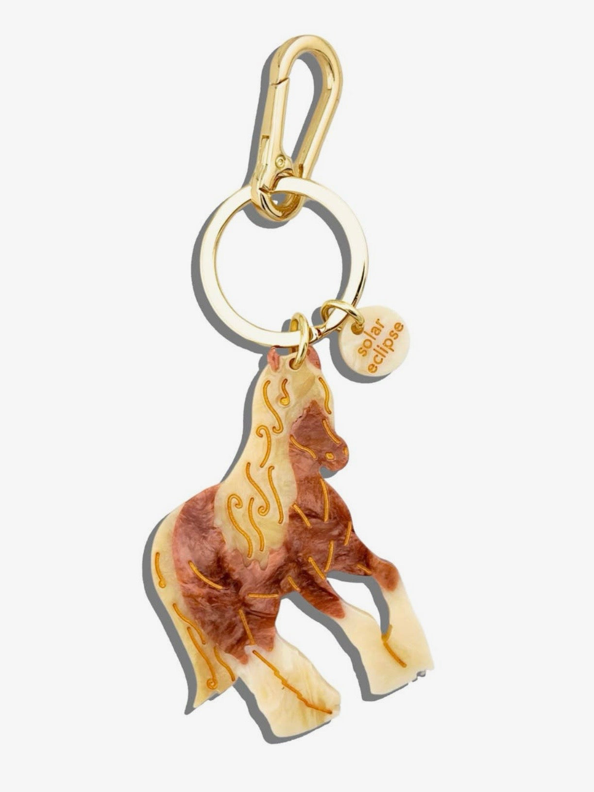 Solar Eclipse horse keychain in cream and brown resin with gold etched details and gold-tone clasp.