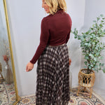 Brown and cream plaid maxi skirt styled with burgundy turtleneck top, flowing tiered silhouette, elastic waistband.