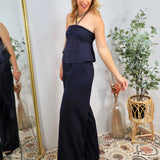 Woman wearing navy blue strapless halter top and matching wide-leg flowy pants, styled as elegant coordinated set in bohemian