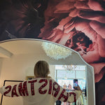 White "Christmas" crewneck sweatshirt with red festive lettering, shown from the back in a boutique mirror selfie.