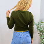 Olive green cropped cardigan with mustard trim detailing, worn over light wash blue jeans, back view.