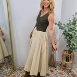 Olive green sleeveless bodice midi dress with cream skirt, button front detail, styled with brown boots and pearl necklace.