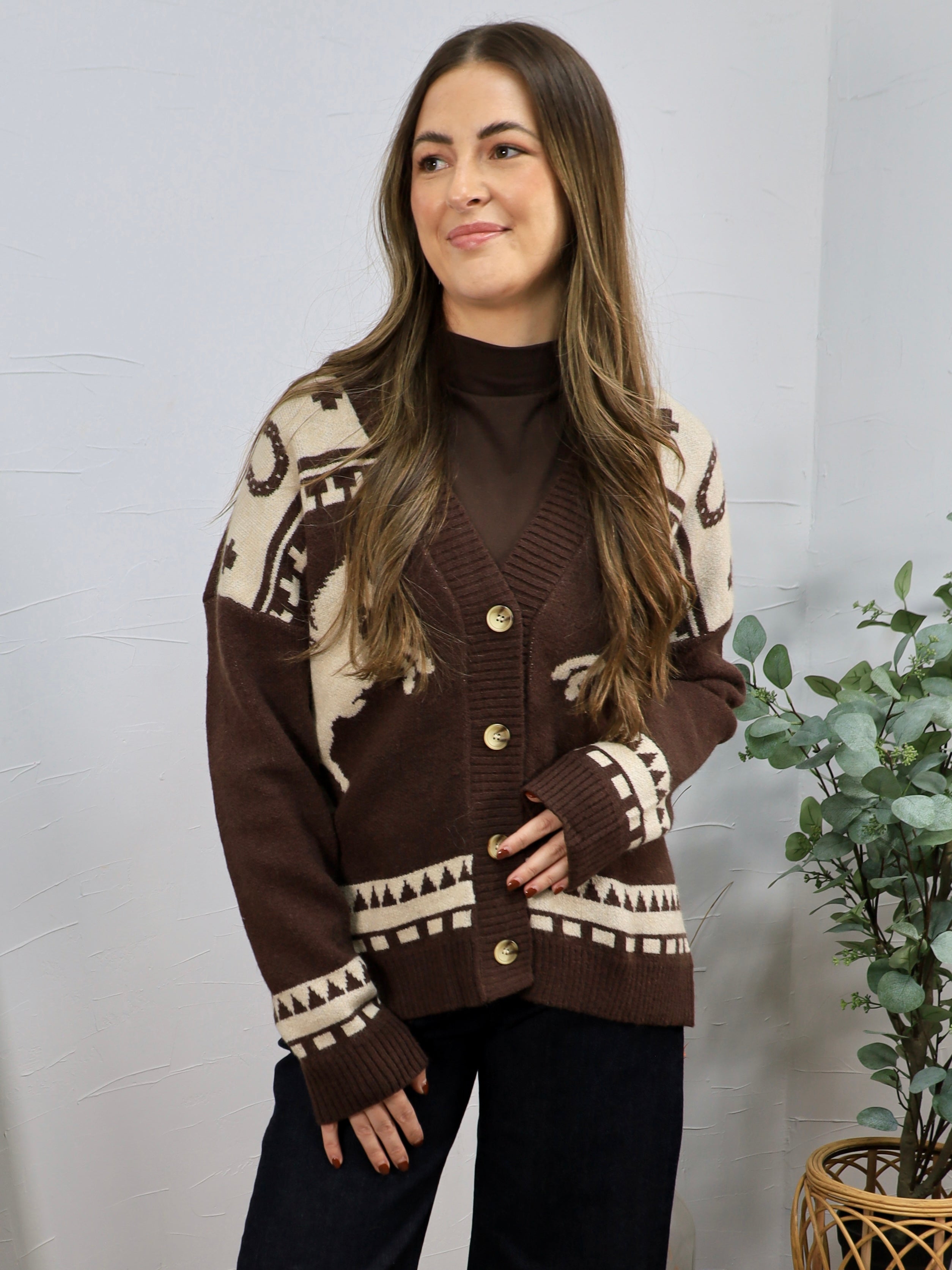 Brown and cream western-patterned knit cardigan with gold buttons, layered over brown turtleneck.