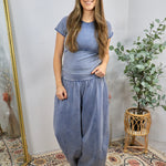 Mineral-washed blue short-sleeve fitted crop top with seam detail, styled with matching wide-leg pants.