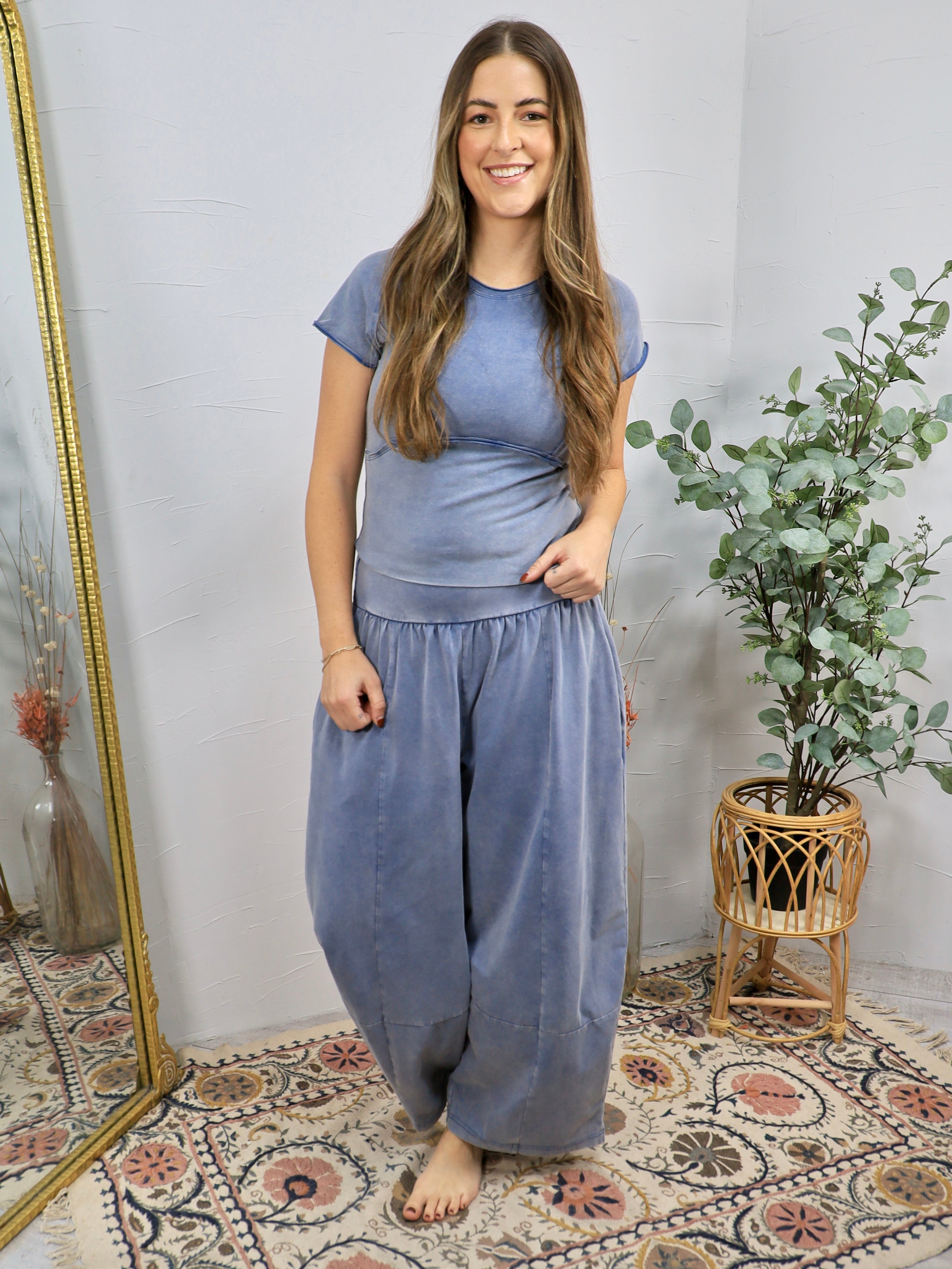 Mineral-washed blue short-sleeve fitted crop top with seam detail, styled with matching wide-leg pants.