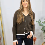 Olive brown button-front cardigan with white contrast trim, layered over white shirt, paired with dark jeans.