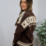 Brown and cream Aztec-patterned oversized knit cardigan shown from the back on a female model.