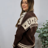 Brown and cream Aztec-patterned oversized knit cardigan shown from the back on a female model.