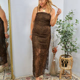 Blonde woman wearing brown sequined midi dress with thin straps and scattered pearl embellishments, styled with platform sand