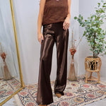 Woman wearing chocolate brown satin wide-leg flare pants with a matching lace cami and suede booties