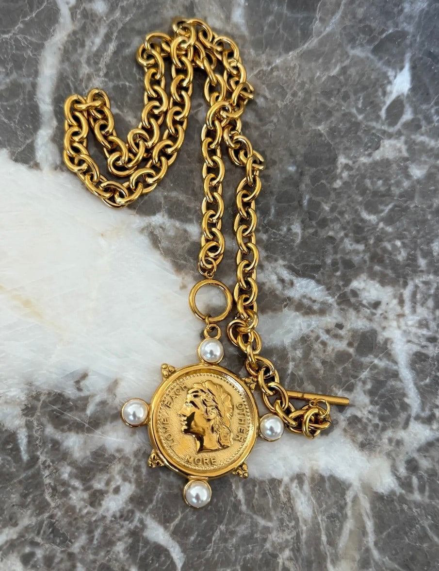 Gold chain necklace featuring a Roman coin pendant with pearl accents and toggle clasp closure.