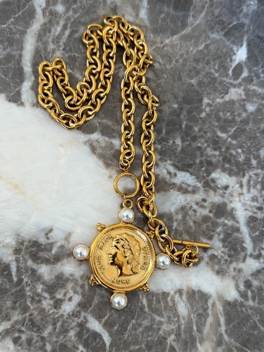 Gold chain necklace featuring a Roman coin pendant with pearl accents and toggle clasp closure.