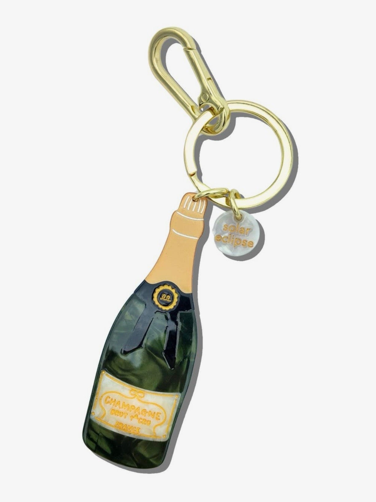 Solar Eclipse champagne bottle keychain with gold carabiner clip, green resin bottle charm, and branded tag.
