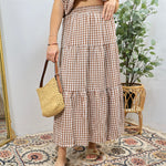 Brown and white gingham tiered midi skirt with elastic waistband worn with woven bag