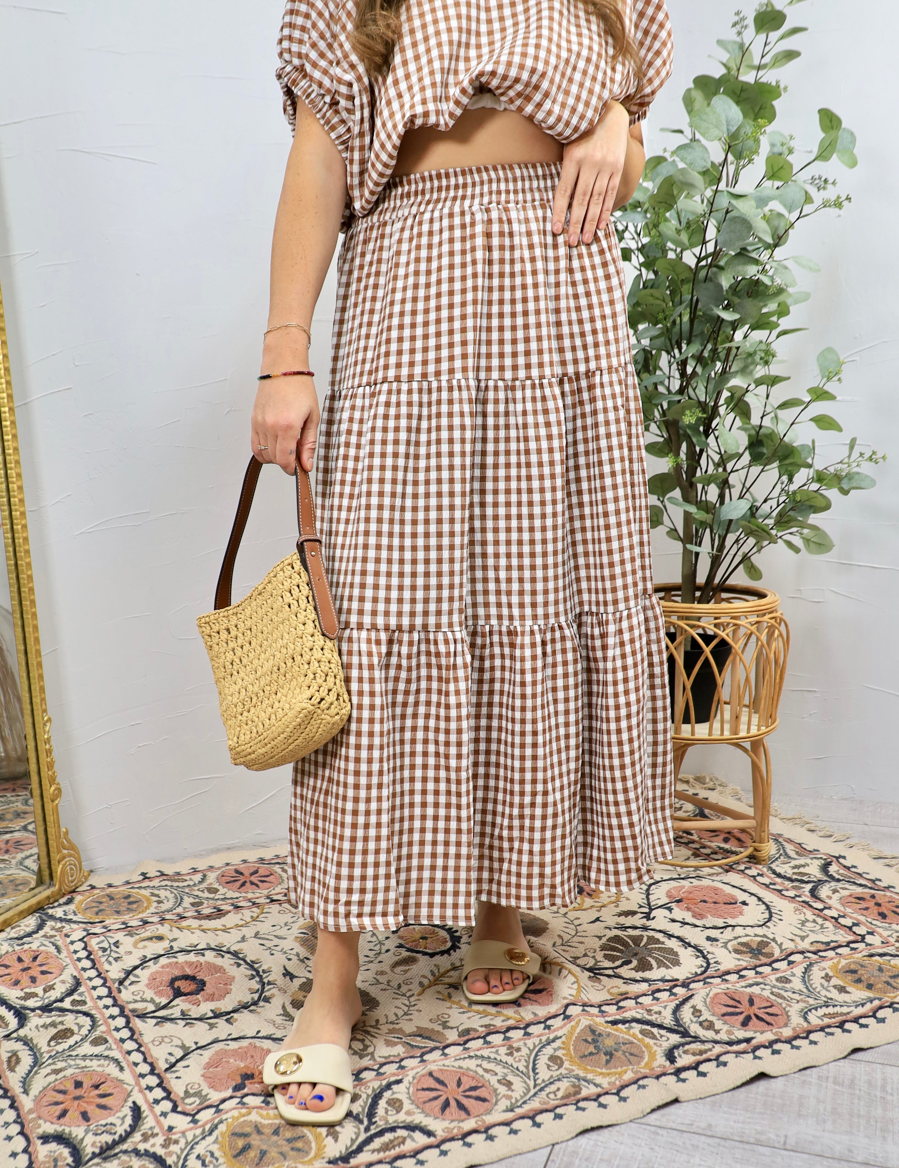 Brown and white gingham tiered midi skirt with elastic waistband worn with woven bag