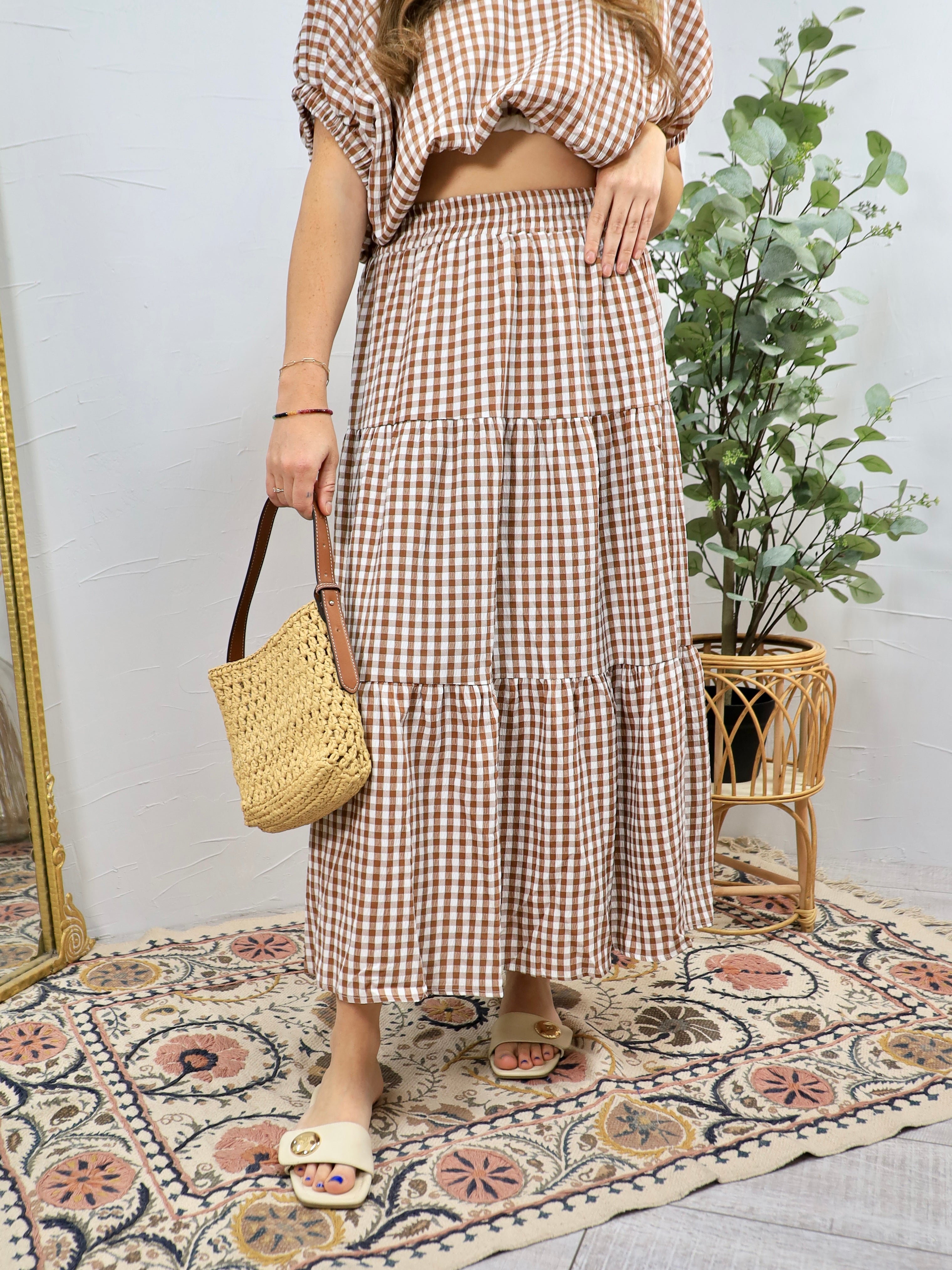 Brown and white gingham tiered midi skirt with elastic waistband worn with woven bag